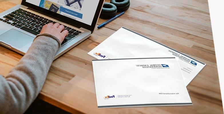 Two GXG® envelopes on a desk being prepared for sending.
