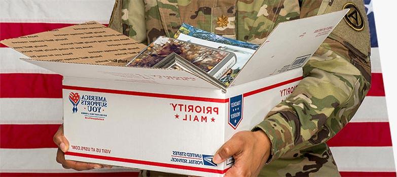 Man in military uniform holding an open package.